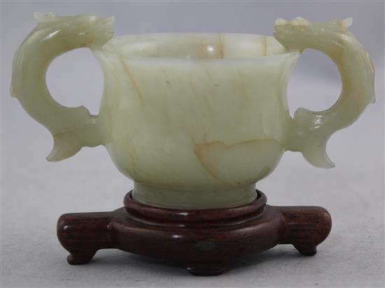 A Chinese bowenite jade two handled cup, Ming dynasty or later, 10.8cm., wood stand